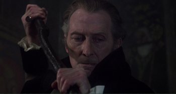 Movie still from “The Vampire Lovers” (1970), directed by Roy Ward Baker – A person holding a stick; Close Up shot, Over the shoulder angle