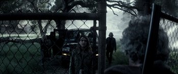 Movie still from “The Veil” (2016), directed by Phil Joanou – A man and a woman are standing in front of a car; Wide shot, Over the shoulder angle
