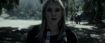 Movie still from “The Veil” (2016), directed by Phil Joanou – A woman with long blonde hair wearing a black and white plaid shirt; Close Up shot, Over the shoulder angle