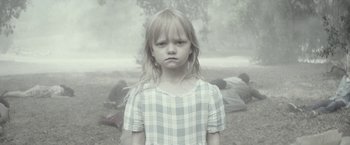 Movie still from “The Veil” (2016), directed by Phil Joanou – A little girl standing in front of a bunch of trees; Medium shot, High angle