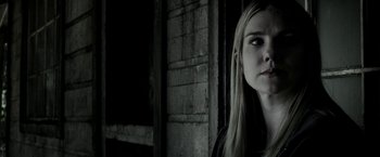 Movie still from “The Veil” (2016), directed by Phil Joanou – A woman with long blonde hair standing next to a wall; Close Up shot, Low angle
