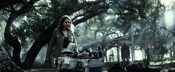 Movie still from “The Veil” (2016), directed by Phil Joanou – A woman standing in front of an outdoor grill; Medium shot, Low angle