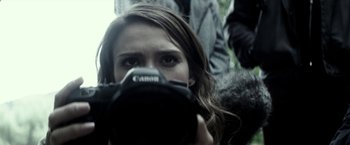 Movie still from “The Veil” (2016), directed by Phil Joanou – A woman taking a picture with a camera; Extreme Close Up shot, Low angle