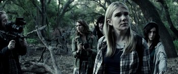 Movie still from “The Veil” (2016), directed by Phil Joanou – A group of people standing next to each other in the woods; Medium shot, Over the shoulder angle