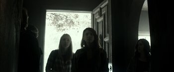 Movie still from “The Veil” (2016), directed by Phil Joanou – Two women standing in front of an open door; Medium shot, Low angle