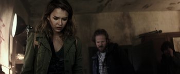 Movie still from “The Veil” (2016), directed by Phil Joanou – A woman standing next to a man in a dark room; Medium shot, Over the shoulder angle