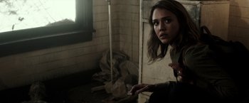 Movie still from “The Veil” (2016), directed by Phil Joanou – A young woman is standing in an abandoned building; Medium shot, Over the shoulder angle