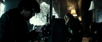 Movie still from “The Veil” (2016), directed by Phil Joanou – A man and a woman working on a camera; Medium shot, Over the shoulder angle