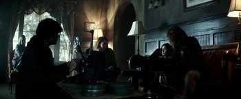 Movie still from “The Veil” (2016), directed by Phil Joanou – A group of people sitting around a table; Wide shot, Over the shoulder angle