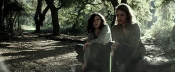 Movie still from “The Veil” (2016), directed by Phil Joanou – Two women sitting on a bench in the woods; Medium shot, High angle
