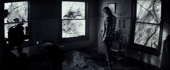 Movie still from “The Veil” (2016), directed by Phil Joanou – A woman standing in front of a window in a room; Wide shot, High angle