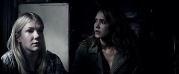 Movie still from “The Veil” (2016), directed by Phil Joanou – A woman in a green jacket looking to her left; Close Up shot, Over the shoulder angle