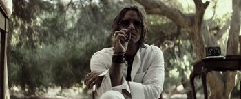Movie still from “The Veil” (2016), directed by Phil Joanou – A man in a white shirt smoking a cigarette outdoors; Close Up shot, Low angle