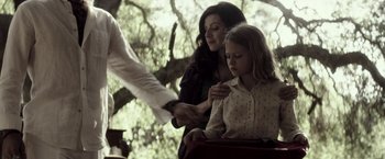 Movie still from “The Veil” (2016), directed by Phil Joanou – A woman and a girl are standing in front of a tree; Medium shot, Over the shoulder angle