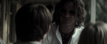 Movie still from “The Veil” (2016), directed by Phil Joanou – A man in sunglasses talking to another man in a white shirt; Close Up shot, Over the shoulder angle