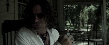 Movie still from “The Veil” (2016), directed by Phil Joanou – A man with long hair wearing a white shirt and tie; Close Up shot, Low angle