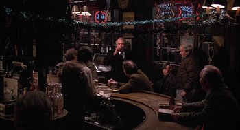 Movie still from “The Verdict” (1982), directed by Sidney Lumet – A group of people sitting around a bar; Wide shot, Over the shoulder angle