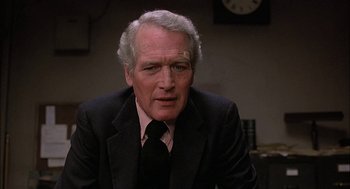 Movie still from “The Verdict” (1982), directed by Sidney Lumet – An older man wearing a suit and tie in front of a wall clock; Close Up shot, Low angle