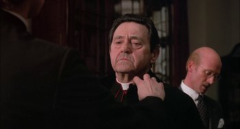Movie still from “The Verdict” (1982), directed by Sidney Lumet – An older man wearing a priest's collar; Close Up shot, Low angle