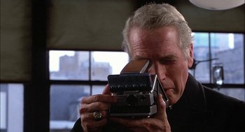 Movie still from “The Verdict” (1982), directed by Sidney Lumet – An older man holding an old camera in front of his face; Extreme Close Up shot, Low angle