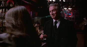 Movie still from “The Verdict” (1982), directed by Sidney Lumet – An older man wearing a suit and tie holding a glass of beer; Medium shot, Over the shoulder angle