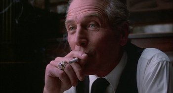 Movie still from “The Verdict” (1982), directed by Sidney Lumet – An older man wearing a suit and tie smoking a cigarette; Close Up shot, Low angle