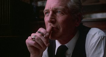 Movie still from “The Verdict” (1982), directed by Sidney Lumet – An older man smoking a cigarette while wearing a suit and tie; Close Up shot, Low angle