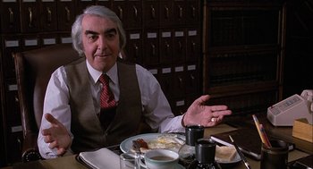 Movie still from “The Verdict” (1982), directed by Sidney Lumet – An older man sitting at a table with a plate of food; Medium shot, Low angle