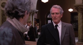 Movie still from “The Verdict” (1982), directed by Sidney Lumet – An older man wearing a suit talking to a woman; Medium shot, Over the shoulder angle