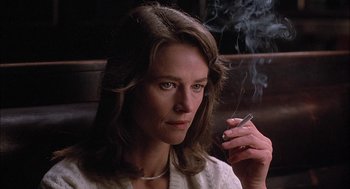 Movie still from “The Verdict” (1982), directed by Sidney Lumet – A woman sitting down with a cigarette in her mouth; Close Up shot, Low angle