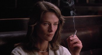 Movie still from “The Verdict” (1982), directed by Sidney Lumet – A woman sitting in front of a window holding a cigarette; Close Up shot, Low angle