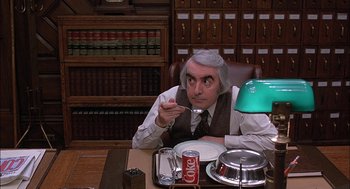 Movie still from “The Verdict” (1982), directed by Sidney Lumet – An older man sitting at a table with a plate of food; Medium shot, High angle