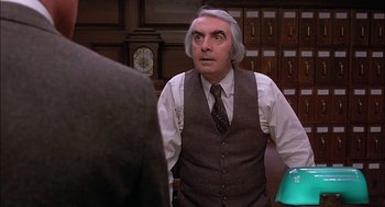 Movie still from “The Verdict” (1982), directed by Sidney Lumet – An older man in a vest and tie is looking at the camera; Medium shot, Over the shoulder angle