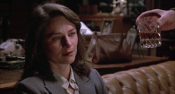 Movie still from “The Verdict” (1982), directed by Sidney Lumet – A person sitting on a couch wearing a suit; Close Up shot, Over the shoulder angle