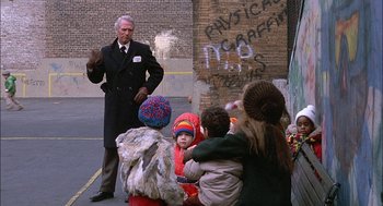 Movie still from “The Verdict” (1982), directed by Sidney Lumet – A group of children and a man standing in front of a building; Wide shot, Over the shoulder angle