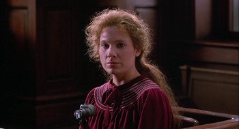 Movie still from “The Verdict” (1982), directed by Sidney Lumet – A woman with long blonde curly hair wearing a red dress; Close Up shot, Low angle