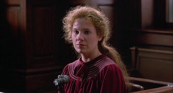 Movie still from “The Verdict” (1982), directed by Sidney Lumet – A woman with long blonde curly hair wearing a red dress; Close Up shot, Over the shoulder angle