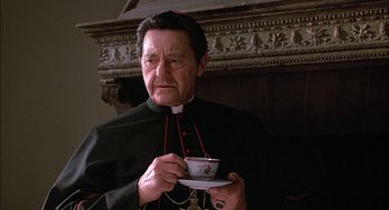 Movie still from “The Verdict” (1982), directed by Sidney Lumet – A man in a priest's outfit holding a tea cup; Close Up shot, Low angle