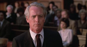 Movie still from “The Verdict” (1982), directed by Sidney Lumet – A man in a suit and tie in front of a group of people; Close Up shot, Low angle