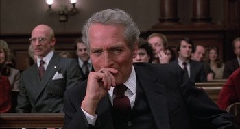 Movie still from “The Verdict” (1982), directed by Sidney Lumet – An older man in a suit and tie in front of a group of people; Close Up shot, Low angle
