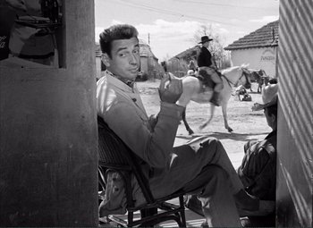 Movie still from “The Wages of Fear” (1953), directed by Henri-Georges Clouzot – A black and white photo of a man sitting in a chair; Medium shot, Low angle