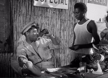Movie still from “The Wages of Fear” (1953), directed by Henri-Georges Clouzot – A black and white photo of two men drinking and eating; Medium shot, Low angle