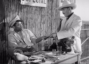 Movie still from “The Wages of Fear” (1953), directed by Henri-Georges Clouzot – Two men in cowboy hats are shaking hands over a table; Medium shot, Low angle