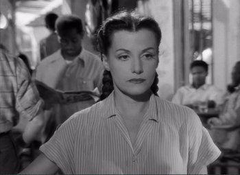 Movie still from “The Wages of Fear” (1953), directed by Henri-Georges Clouzot – A black and white photo of a woman in a striped shirt; Close Up shot, Over the shoulder angle