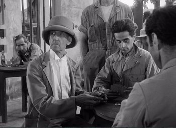Movie still from “The Wages of Fear” (1953), directed by Henri-Georges Clouzot – Two men sitting at a table playing a card game; Medium shot, Over the shoulder angle