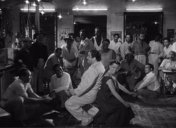 Movie still from “The Wages of Fear” (1953), directed by Henri-Georges Clouzot – Black and white photograph of a group of men and women; Wide shot, High angle