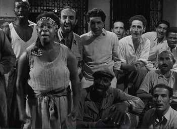 Movie still from “The Wages of Fear” (1953), directed by Henri-Georges Clouzot – A group of people posing for a picture in black and white; Medium shot, High angle
