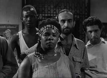 Movie still from “The Wages of Fear” (1953), directed by Henri-Georges Clouzot – Black and white photograph of a group of men and women; Medium shot, Low angle