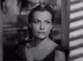 Movie still from “The Wages of Fear” (1953), directed by Henri-Georges Clouzot – Black and white photograph of a woman in front of a wooden fence; Close Up shot, High angle