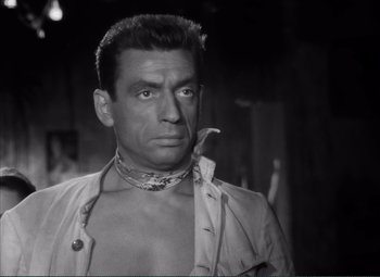 Movie still from “The Wages of Fear” (1953), directed by Henri-Georges Clouzot – A black and white photo of a man with a snake in his mouth; Close Up shot, High angle